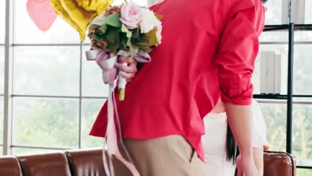 アジアの若い男性は,自宅で彼女の記念日のためにバラと花束を与えることによって,彼女のガールフレンドを驚かせました. アジアの女性は,彼女のボーイフレンドから花束を受け取るのが好きです. バレンタインデーのお祝い - 映像、動画