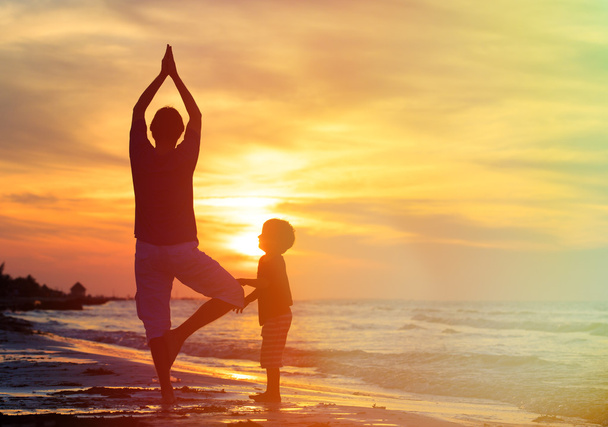 Vater und Sohn machen Yoga bei Sonnenuntergang - Foto, Bild