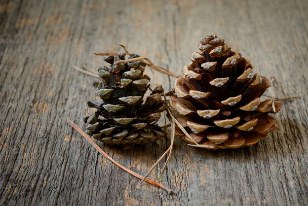 Dois cones de abeto com fundo de madeira
 - Foto, Imagem