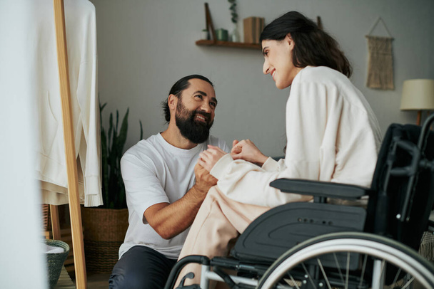 good looking cheerful man spending time with his beautiful disabled wife while in bedroom at home - Photo, Image
