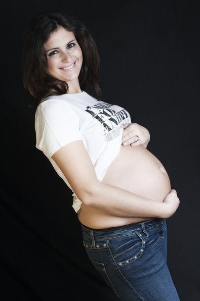 Happy pregnant on a black background - Foto, imagen