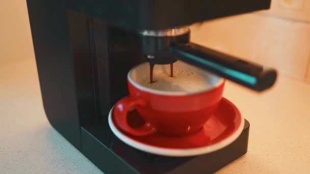 Kaadan kahvia koneesta kuppiin. Kotona tekemässä espressoa. Käytetään suodatinpidikettä. Tuoretta jauhettua kahvia. Juominen paahdettu musta kahvi aamulla.High quality FullHD kuvamateriaalia - Materiaali, video