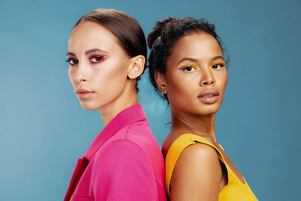 Frau Modell Rennen afrikanische Mädchen attraktiv gesund Studio schön zusammen gelb Porträt amerikanisch zwei bunte Körperpflege Haut glücklich Make-up Schönheit Gesicht gemischten Glanz - Foto, Bild