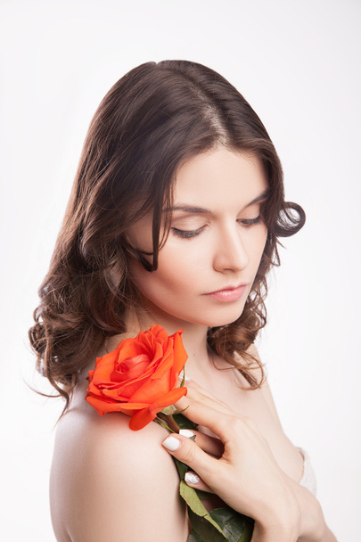portrait of beautiful brunette woman with red rose - 写真・画像