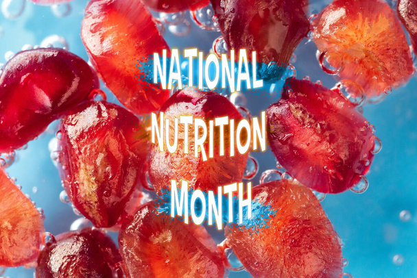 A gyümölcsök és pezsgő buborékok képezik a hátterét a merész nemzeti táplálkozási hónap szövegének, kiemelve az egészséges táplálkozás fontosságát.. - Fotó, kép
