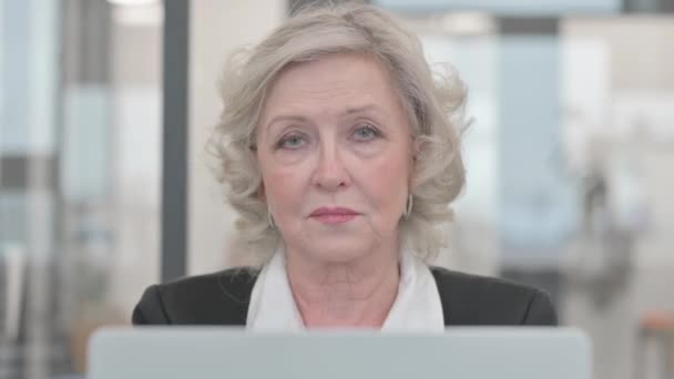 Close up of Senior Businesswoman Patrząc w kamerę w pracy - Materiał filmowy, wideo
