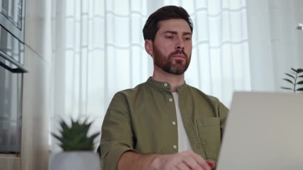 Közelkép szakállas szabadúszó befejező dolgozik laptop és úgy dönt, hogy meditál a személyes munkahelyen. Fáradt férfi becsukja a szemét, és összpontosít a jólét a jóga folyamat során irodai szék. - Felvétel, videó