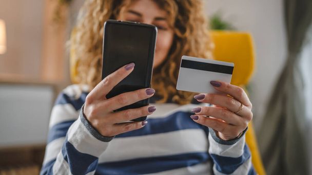 Eine erwachsene kaukasische Frau zu Hause glücklich lächeln halten Bank Kreditkarte Online-Shopping E-Banking-Konzept echte Menschen kopieren Raum E-Commerce machen Kauf oder Buchung - Foto, Bild