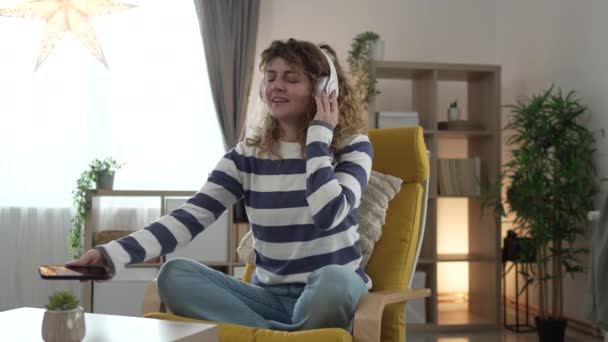 een vrouw volwassen Kaukasische vrouw millennial met behulp van koptelefoon voor online geleide meditatie beoefenen mindfulness yoga met ogen dicht thuis echte mensen zelfzorg concept slow motion - Video