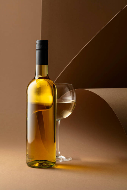 Bottle and glass of white wine on a beige background. Copy space. - Foto, Imagem
