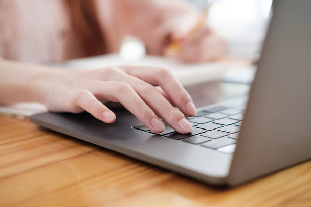 Szczegółowy widok kobiecych dłoni piszących na nowoczesnym laptopie, rejestrujących istotę cyfrowego przepływu pracy. - Zdjęcie, obraz