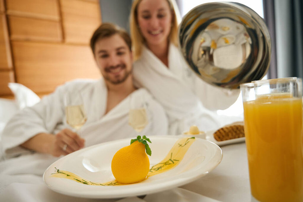 Nainen ja mies nauttivat samppanjaa aamiainen, pöytä asetettu suuri sänky - Valokuva, kuva