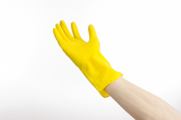 Homework, washing and cleaning of the theme: man's hand holding a yellow and wears rubber gloves for cleaning isolated on white background in studio - Photo, image