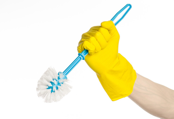 Cleaning the house and cleaning the toilet: human hand holding a blue toilet brush in yellow protective gloves isolated on a white background in studio - Foto, immagini