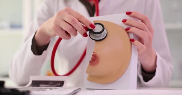 Médica feminina aplica estetoscópio ao modelo de mama realista na clínica. Consulta de oncologista e mamologista - Filmagem, Vídeo