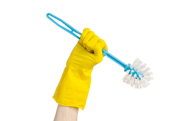 Limpieza de la casa y limpieza del inodoro: mano humana sosteniendo un cepillo de inodoro azul con guantes protectores amarillos aislados sobre un fondo blanco en el estudio
 - Foto, Imagen