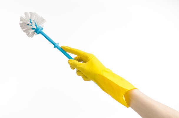 Cleaning the house and cleaning the toilet: human hand holding a blue toilet brush in yellow protective gloves isolated on a white background in studio - Valokuva, kuva