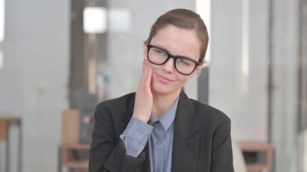 Jeune femme d'affaires inconfortable avec mal de dents au bureau - Séquence, vidéo