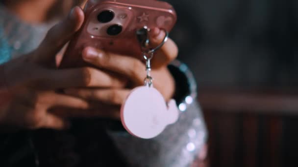 Zbliżenie rąk trzymających smartfon z różową walizką i okrągłym urokiem wewnątrz nawiedzonego domu - Materiał filmowy, wideo