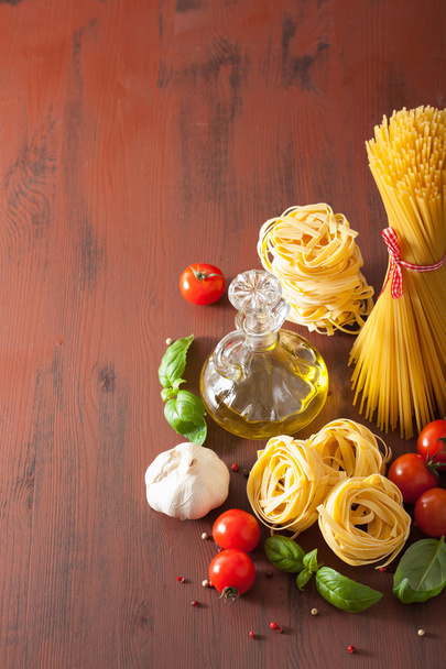 rohe Nudeln Olivenöl Tomaten. Italienische Küche in rustikaler Küche - Foto, Bild