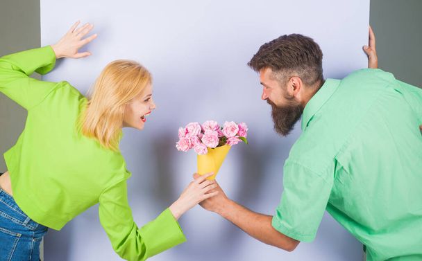Valentines or womens day, anniversary, birthday celebration. Bearded man with bouquet of roses for girlfriend. Smiling man with flowers for beautiful woman. Surprise for girl. Romantic relationships - Photo, Image