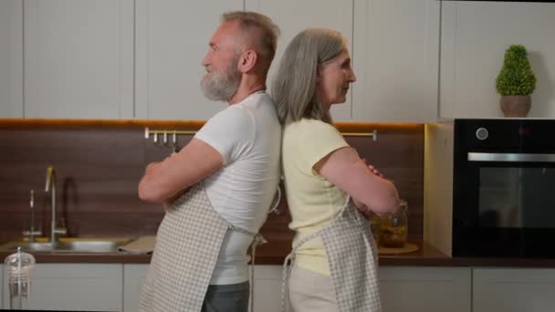 Retraité vieille famille heureuse conjoints d'âge moyen femme mûre homme âgé se tenir à l'autre mains croisées à la maison grand-père couple souriant marié femme et mari cuisinier dans la cuisine retraite - Séquence, vidéo