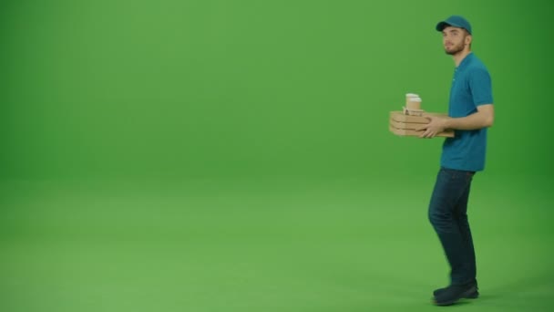 Zielony ekran Portret Przystojny Dostawca Żywności w Uniform Holds Holding Take Away Pizza Pudełka i kawa, Uśmiechy. Pracownik przynoszący Fast Food do biura. - Materiał filmowy, wideo