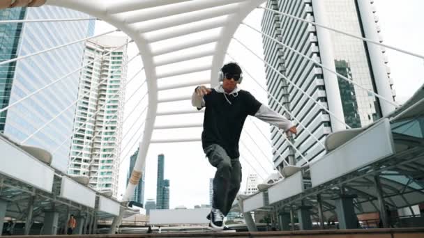 Jonge Aziatische hipster tonen voetstap in het centrum van de stad omgeven door mensen. Stijlvolle mode street danser voeren B-boy of freestyle dansen met een lage hoek. Outdoor sport 2024. Breken dansen. Schitterend.. - Video