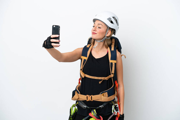 Joven escaladora caucásica aislada sobre fondo blanco haciendo una selfie - Foto, Imagen