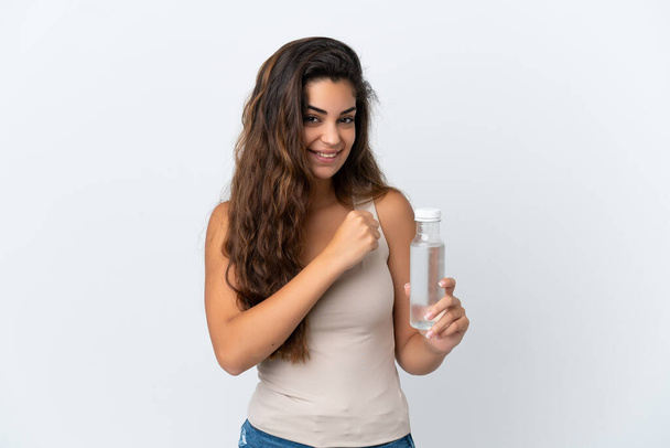 勝利を祝う白い背景に隔離された水のボトルを持つ若い白人女性 - 写真・画像