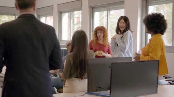 Vidéo au ralenti d'une patronne distribuant des dossiers parmi les employés d'un bureau de coworking - Séquence, vidéo