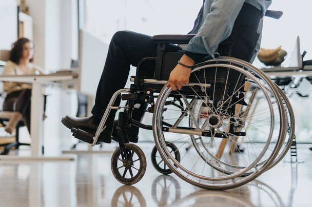 Un hombre discapacitado rodando su silla de ruedas. Foto recortada. - Foto, imagen