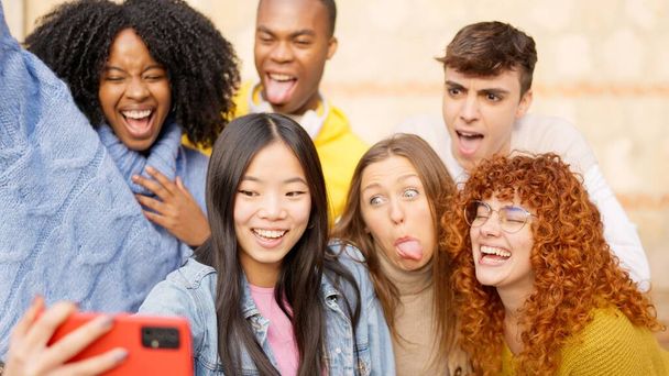 Groupe d'amis prenant un selfie à l'extérieur faisant des visages drôles - Photo, image