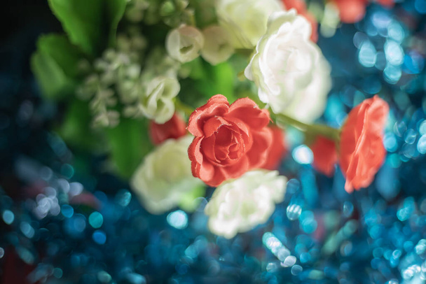 Kleurrijke kunstmatige witte en rode roos bloemen bos op blauwe bokeh achtergrond, Selectieve focus - Foto, afbeelding