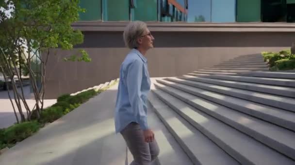 kaukaski dorosły senior businesswoman średnim wieku przedsiębiorca lider ceo pracodawca dojrzały kobieta chodzenie po schodach biurowych budynku na zewnątrz profesjonalny biznes kobieta będzie schody w mieście - Materiał filmowy, wideo