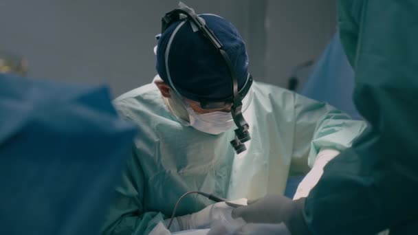 Chirurdzy zespołowi wykonują operacje na sali operacyjnej profesjonalny lekarz prowadzący przy użyciu nowoczesnych medycznych instrumentów endoskopowych Chirurgia serca usuń nowotwór chirurgiczna procedura zdrowotna w szpitalu - Materiał filmowy, wideo