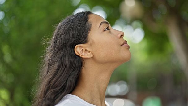 Afrykańska Amerykanka spogląda w niebo z poważnym wyrazem twarzy w parku - Zdjęcie, obraz