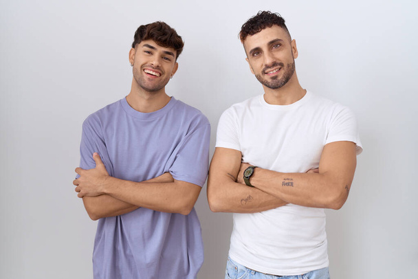 omosessuale gay coppia in piedi oltre bianco sfondo felice faccia sorridente con incrociato braccia guardando il fotocamera. persona positiva.  - Foto, immagini