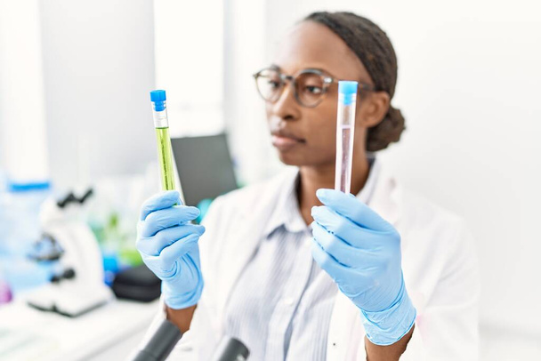 Afrikanische Wissenschaftlerin hält Reagenzgläser im Labor - Foto, Bild