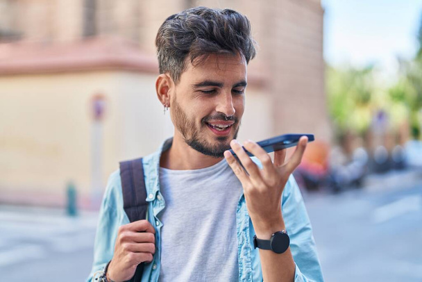 Young hispanic man student smiling confident talking on smartphone at street - Photo, Image