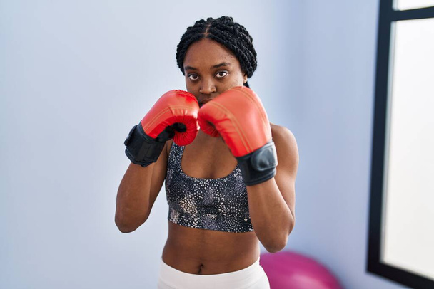 Африканська американка боксує з концентрованим виразом у спортивному центрі. - Фото, зображення