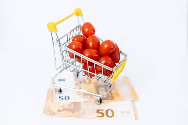 Tomates dans un panier sur les billets. Hausse des prix alimentaires due à la guerre en Ukraine - Photo, image