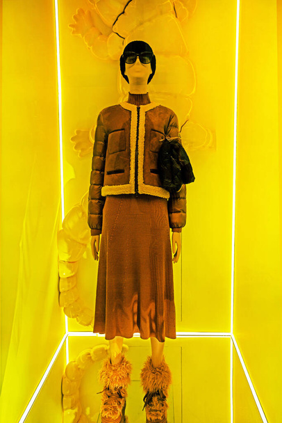 жіночий маннекін у стильному одязі та капелюсі на жовтому фоні - Фото, зображення