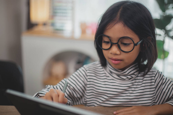 Mignon asiatique petite fille enfants à l'aide d'un ordinateur portable, étudier à travers un système d'apprentissage en ligne. - Photo, image