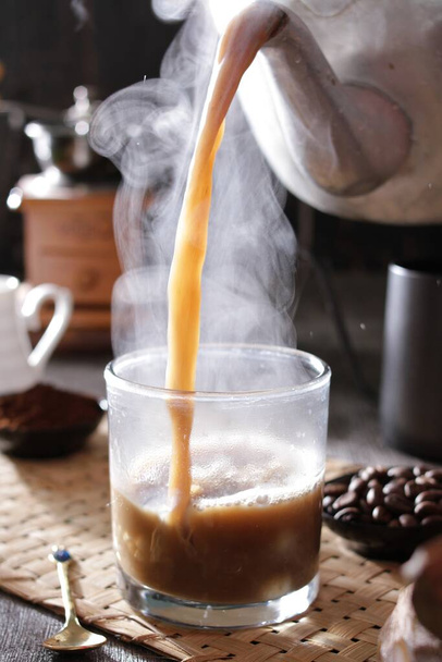 людина наливає чашку кави в склянку - Фото, зображення