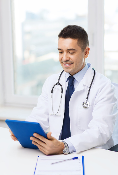 smiling male doctor in white coat with tablet pc - Фото, изображение