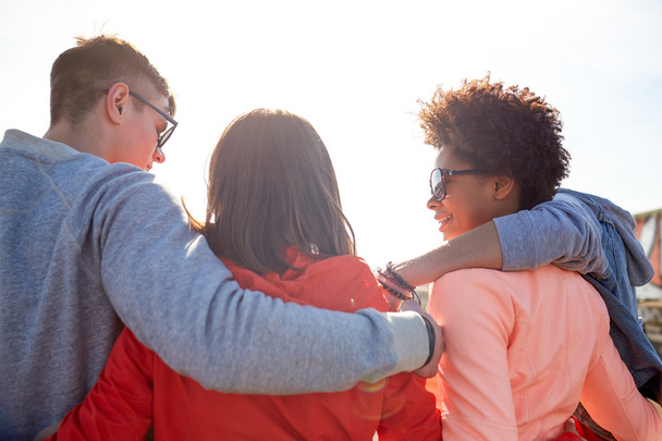 happy teenage friends in shades hugging on street - Foto, immagini