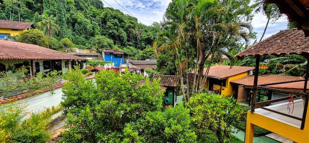 Ilha Grande, Brazylia - 28 stycznia 2024: Vila do Abraao miasto na wyspie Ilha Grande z pięknymi domami i ogrodami. Położony w pobliżu Rio de Janeiro, Brazylia jest idealnym miejscem na ucieczkę od ruchliwego życia miasta. - Zdjęcie, obraz