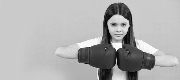 confident child boxer in boxing gloves during sport training, copy space, determination. Horizontal poster of isolated child face, banner header, copy space - Valokuva, kuva
