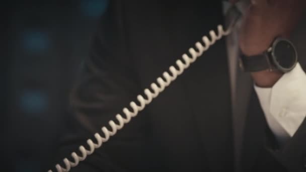 Nachylenie w górę pracoholik Czarny biznesmen wybierając numer telefonu stacjonarnego i patrząc rozmowy telefonicznej podczas przepracowania sam w biurze w nocy - Materiał filmowy, wideo